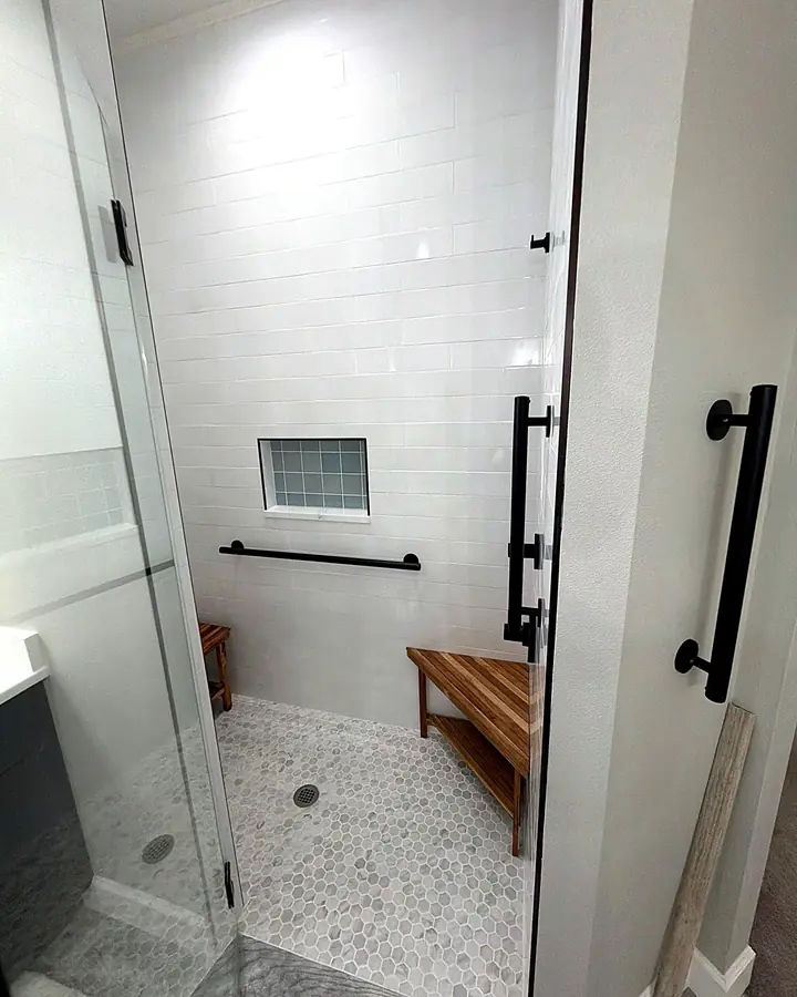 Matte black grab bars inside and just outside a tiled walk-in shower with a glass door, Lake Mary